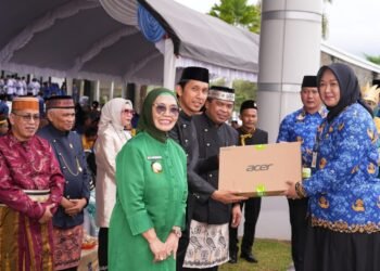 Wali Kota Bontang Neni Moerniaeni baju hijau, Heri Keswanto Ketua Komisi A DPRD Bontang (tengah), dan Wakil Wali Kota Bontang Agus Haris saat penyerahan laptop ke guru di Hardiknas 2025