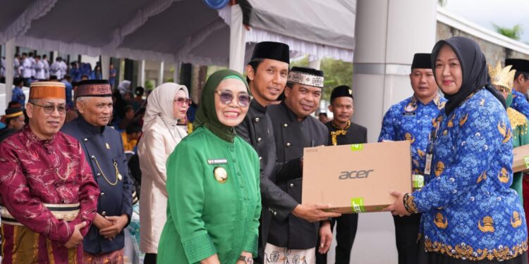 Wali Kota Bontang Neni Moerniaeni baju hijau, Heri Keswanto Ketua Komisi A DPRD Bontang (tengah), dan Wakil Wali Kota Bontang Agus Haris saat penyerahan laptop ke guru di Hardiknas 2025