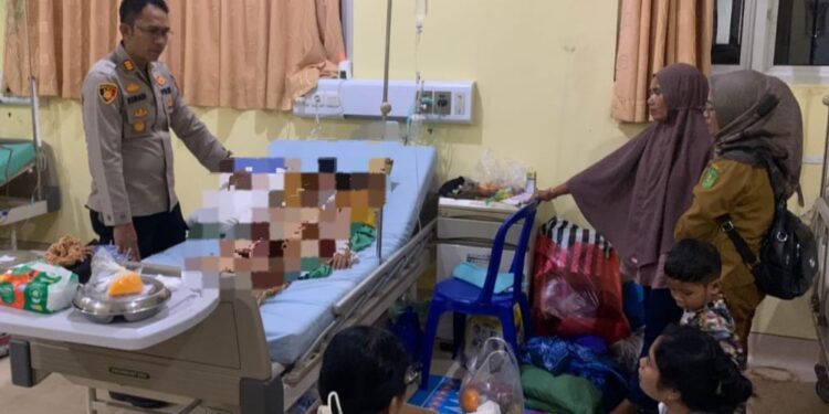 Kapolsek Bengalon AKP Asriadi, bersama Banit Sium Bripda M. Fikran mendatangi kamar perawatan korban, Muhammad Zaki Ramadani, bocah 10 tahun yang sebelumnya diterkam buaya di kolong rumah warga.
