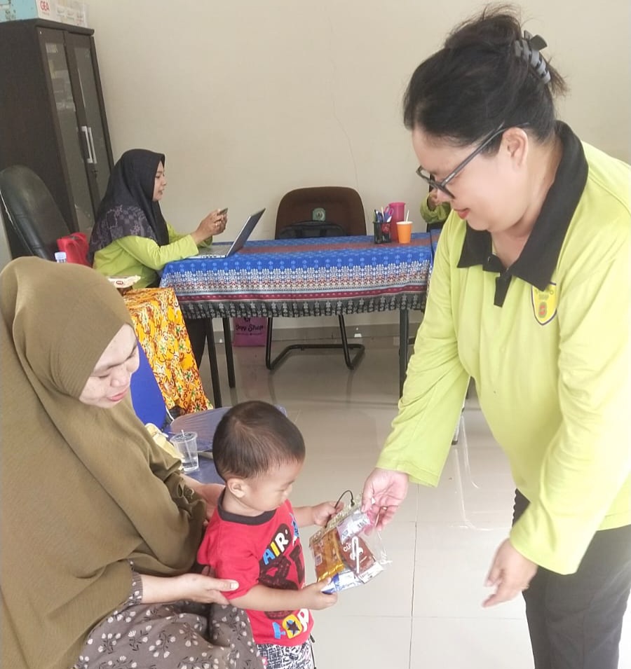 Pemberian susu kepada anak-anak oleh pengurus posyandu usai timbang