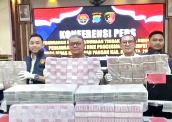 Direktur Reskrimsus Polda Kaltim, dalam konferensi pers di Mapolda Kaltim, memperlihatkan uang sebanyak Rp7 Miliar yang berhasil diselamatkan dalam proyek pengadaan RPU Distan Kutim TA 2024, Rabu (3/12/2025) (Dok: Han/katakaltim)