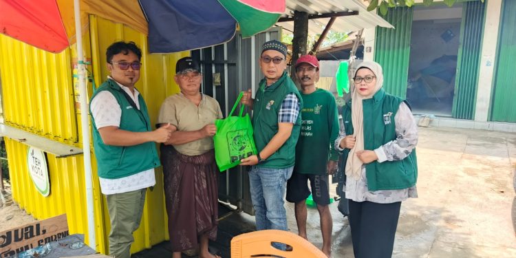 Ketua DPC PKB Bontang, Firman, berserta jajaran pengurus bagikan sembako ke warga