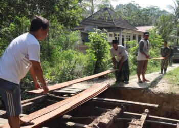 Personel Kodim 0908/Bontang bersama warga dan Kelurahan Gunung Telihan bergotong royong memperbaiki jembatan