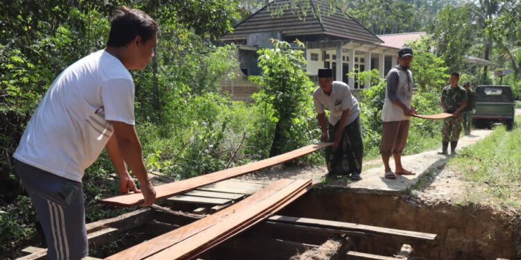 Personel Kodim 0908/Bontang bersama warga dan Kelurahan Gunung Telihan bergotong royong memperbaiki jembatan