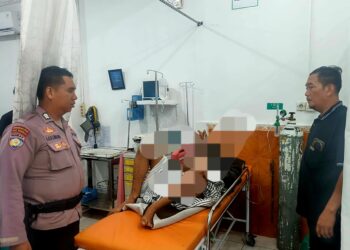 Pihak kepolisian bersama warga memabawa pria diduga jatuh saat mencuri mangga ke rumah sakit