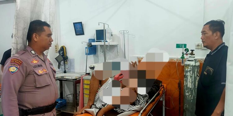 Pihak kepolisian bersama warga memabawa pria diduga jatuh saat mencuri mangga ke rumah sakit